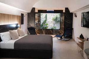 a bedroom with a bed and chairs in a room at Dimora in Cortile in Manfredonia