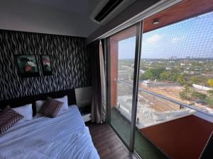 a bedroom with a bed and a large window at Weekend address in Surat