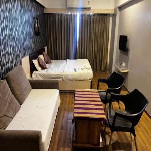 a living room with a couch and a bed at Weekend address in Surat +11 photos