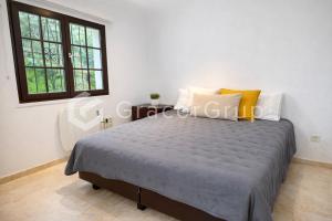 a bedroom with a bed and two windows at Casa El Trebol in L'Escala +18 photos