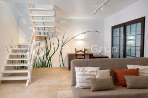 a living room with a staircase and a couch at Casa El Trebol in L'Escala