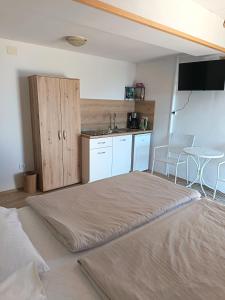 a large bed in a room with a kitchen at Studio apartman Belvedere in Motovun