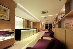 a salon with purple chairs and a waiting room at Candeo Hotels Handa in Handa