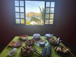 a table with many different types of food on it at Recanto do sol in Mangaratiba