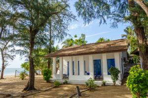 a cottage on the beach with trees at Tsunami beach hotel arugambay in Pottuvil
