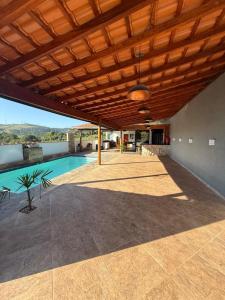 an outdoor patio with a pool and a wooden ceiling at Recanto Feitosa Taubate in Taubaté