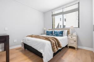 a white bedroom with a large bed and a window at Built on Hope De Waterkant in Cape Town +15 photos