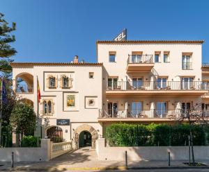 a large white building with balconies on it at Hotel Canal Olímpic in Castelldefels