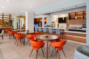 a restaurant with tables and chairs and a kitchen at EVEN Hotel Alpharetta - Avalon Area by IHG in Alpharetta