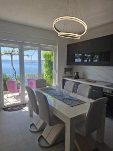 a kitchen and dining room with a table and chairs at Guest House Perla in Sveti Juraj