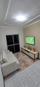 a living room with a couch and a flat screen tv at Tesouro da Maraponga in Fortaleza