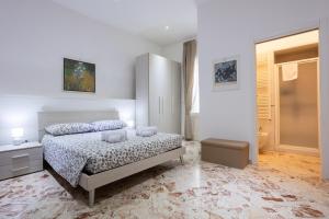 a white bedroom with a bed and a nightstand and a bed sidx sidx sidx at A Casa di Paola B&B Lecce in Lecce