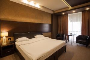 a hotel room with a bed and two chairs at Avangard Hotel in Yerevan