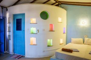 a bedroom with a bed and a wall with lights at Tsunami beach hotel arugambay in Pottuvil