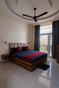a bedroom with a bed with a ceiling fan at The Whistling Pine Homestay With Natural Swimming Pool in Lansdowne