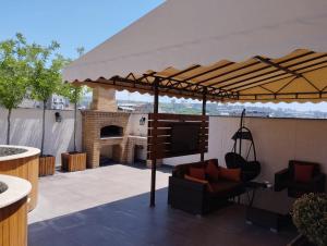 a large umbrella on a patio with a fireplace at Avangard Hotel in Yerevan +3 photos