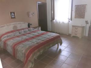 a bedroom with a bed and a tiled floor at Bellavista Coghinas in Oschiri