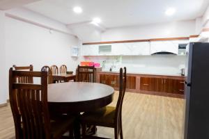 a kitchen with a table and chairs and a refrigerator at Jhigu Casa Homestay in Kirtipur