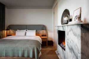 a bedroom with a bed and a fireplace at CORI Hornbæk Hotel in Hornbæk