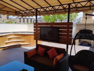 a patio with a couch and a television on a roof at Avangard Hotel in Yerevan