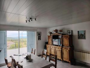 a dining room with a table and a tv at VIDAL BERNARD in Saint-André-de-Vézines