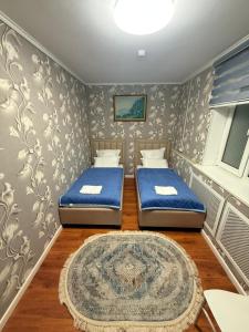 two beds in a small room with a rug at Duman House in Almaty +29 photos