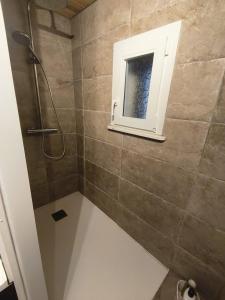 a bathroom with a shower with a window at Garden Lodge Formiguères in Formiguères