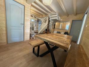 a large wooden table in a room with a staircase at Garden Lodge Formiguères in Formiguères