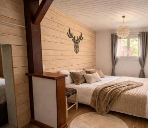 a bedroom with a bed with a deer head on the wall at Garden Lodge Formiguères in Formiguères