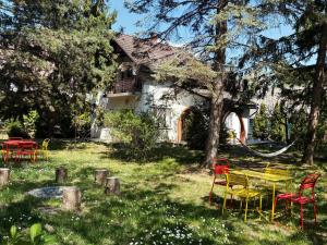 a group of chairs and tables in front of a house at Endretro Apartments in Siófok
