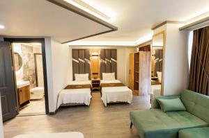 ein Hotelzimmer mit zwei Betten und einer Couch in der Unterkunft Hotel Milano in Rize