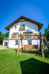 a white house with a bench in front of it at Apartamenty Pawełek in Zator