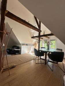 a dining room with a table and chairs in a attic at studio 50m2 au bord de l'eau à STRASBOURG in Strasbourg
