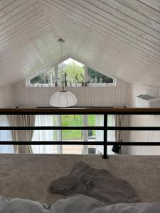 a white room with a large window and a chandelier at Domeček pod lípou in Neveklov +3 photos