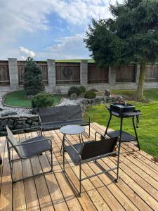 a patio with a grill and chairs and a table at Domeček pod lípou in Neveklov