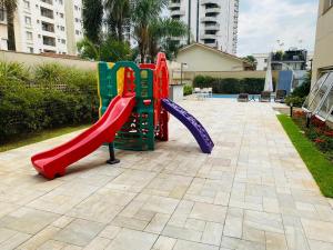 a playground with a slide in a courtyard at Flat Vila Olimpia Hotel Experience in São Paulo