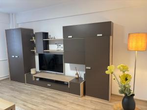 a living room with a large entertainment center with a tv at Sunny Apartment in Constanţa