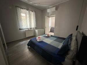 a bedroom with a blue bed and a window at Mazzini Home in Cosenza