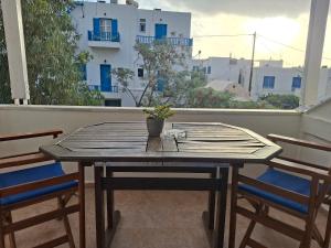 a wooden table on a balcony with two chairs at Aegeon Pension in Aegiali +43 photos