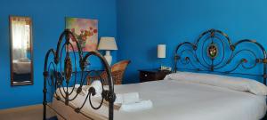 a bedroom with a bed with a blue wall at La Casa de la Huerta in Vinuesa
