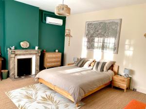 a bedroom with a large bed and a fireplace at Le Petit Jard'Inn in Chalons en Champagne