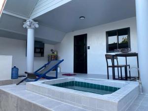 a swimming pool in a room with a table and a chair at Banpu Beach Ao Lung Dam,Koh Samet in Ao Phutsa