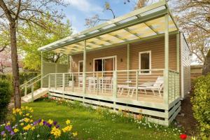 a house with a deck with a pergola at Parco delle Piscine in Sarteano