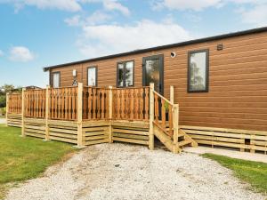 a home with a wooden deck and a house at Hedgehog Lodge in Carnforth