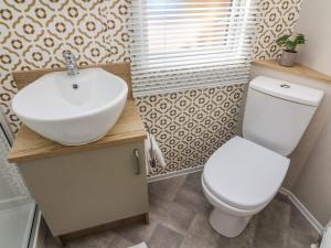 a bathroom with a white sink and a toilet at Hedgehog Lodge in Carnforth +14 photos