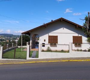 a white building with two windows and a fence at Hospedaria AlpenGlück in Treze Tílias