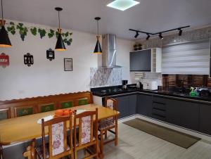 a kitchen with a wooden table and a dining room at Hospedaria AlpenGlück in Treze Tílias