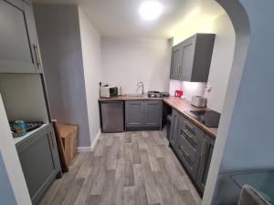 a kitchen with gray cabinets and a wooden floor at Mailbox and Broad St in Birmingham