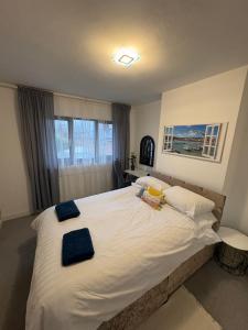 a bedroom with a large white bed with blue towels on it at Hollemeadow in Bloxwich