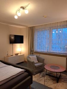 a hotel room with a bed and a chair and a window at Heimathafen in Büsum